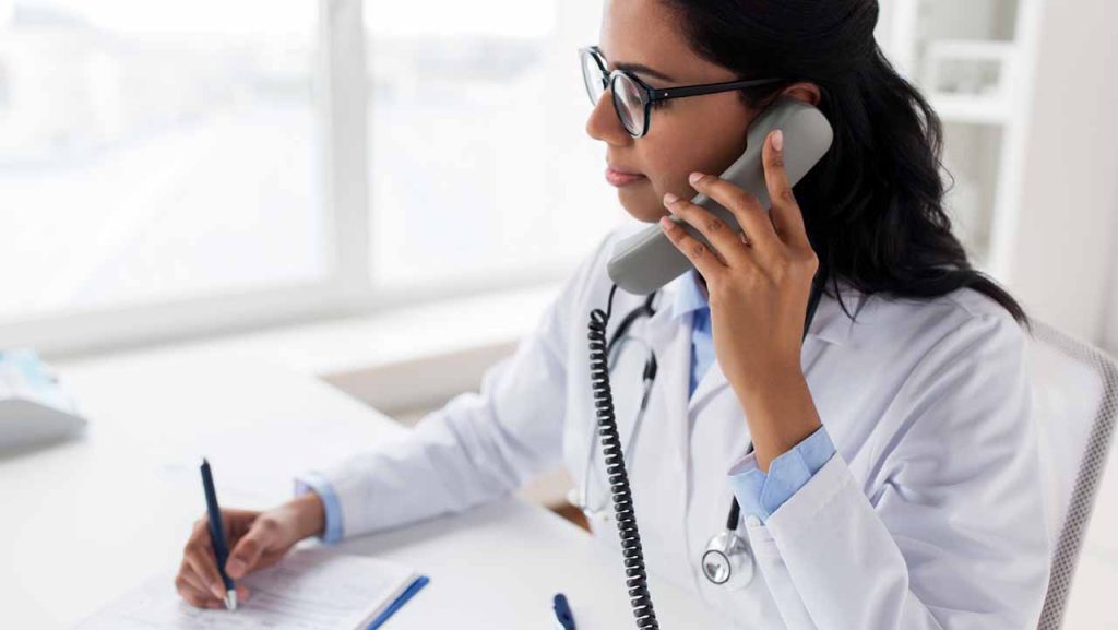 A female doctor in a white coat on the telephone