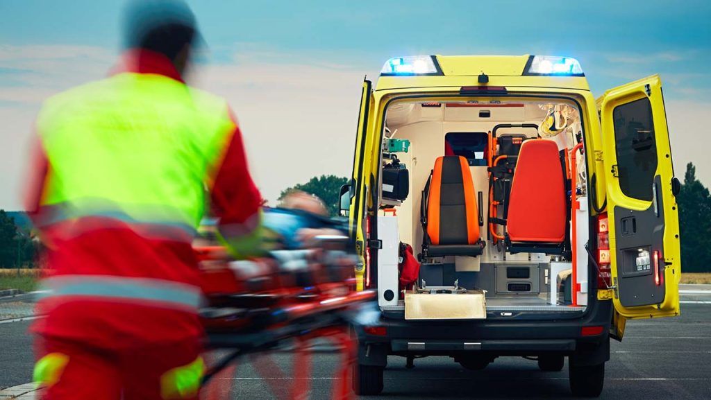 An emergency personnel rushing a stretcher to the ambulance